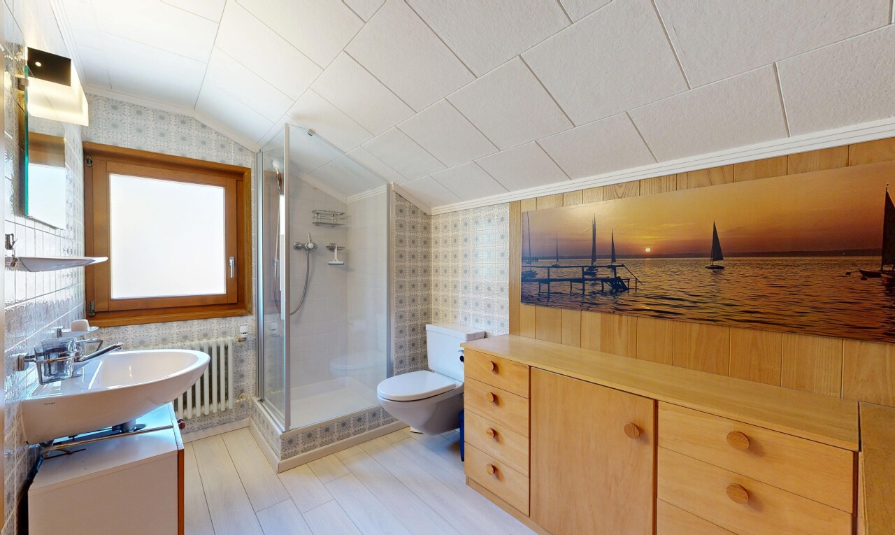 salle de bains avec lavabo (ou coiffeuse selon le contexte), toilette, douche, mur en papier peint, et wallpaper wall