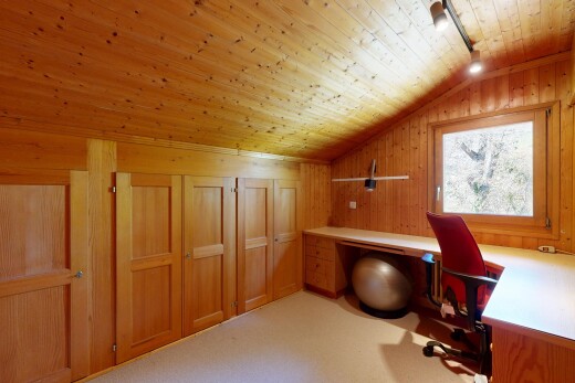 office area featuring a vaulted wooden ceiling, rail lighting, wooden walls, light colored carpet, and built in study area