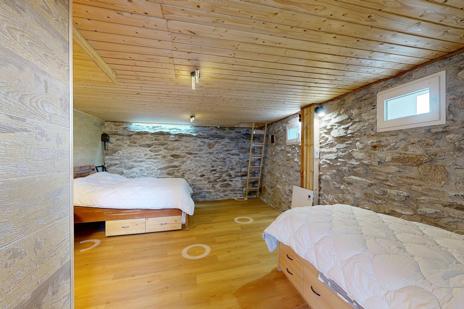 chambre avec mur en pierre, stone wall, plafond en bois, wood ceiling, et sol en finition bois