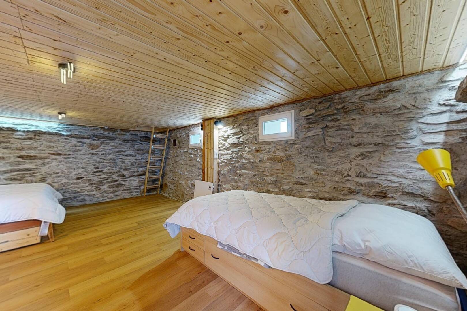 chambre avec mur en pierre, stone wall, plafond bas, low ceiling, et sol en finition bois