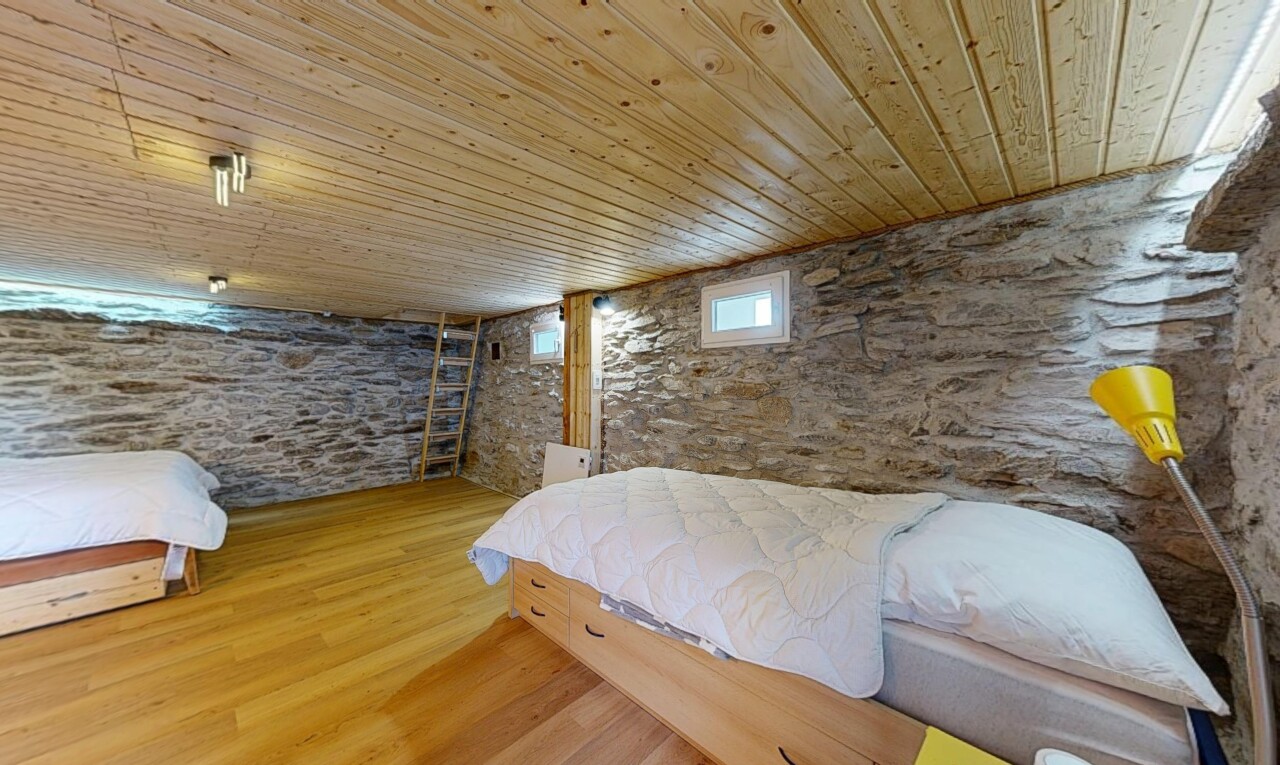 chambre avec mur en pierre, stone wall, plafond bas, low ceiling, et sol en finition bois