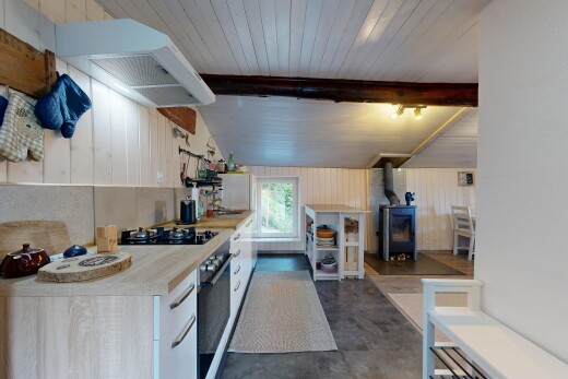 cuisine avec poêle à bois, lumière naturelle, hotte, concrete floor, et sol en béton