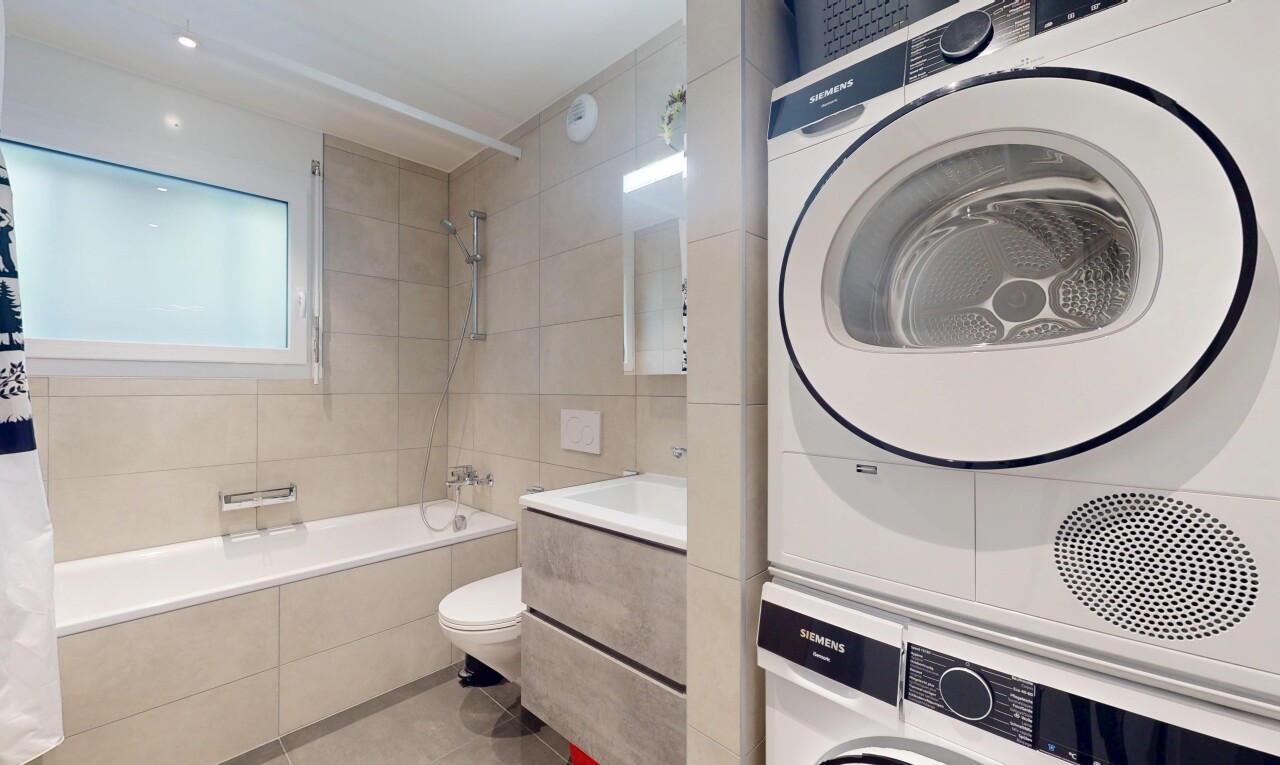 salle de bains avec tile tub, lave-linge et sèche-linge superposés, inside property, douche-bain combinés, et sol en carrelage