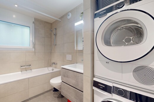 salle de bains avec tile tub, lave-linge et sèche-linge superposés, inside property, douche-bain combinés, et sol en carrelage