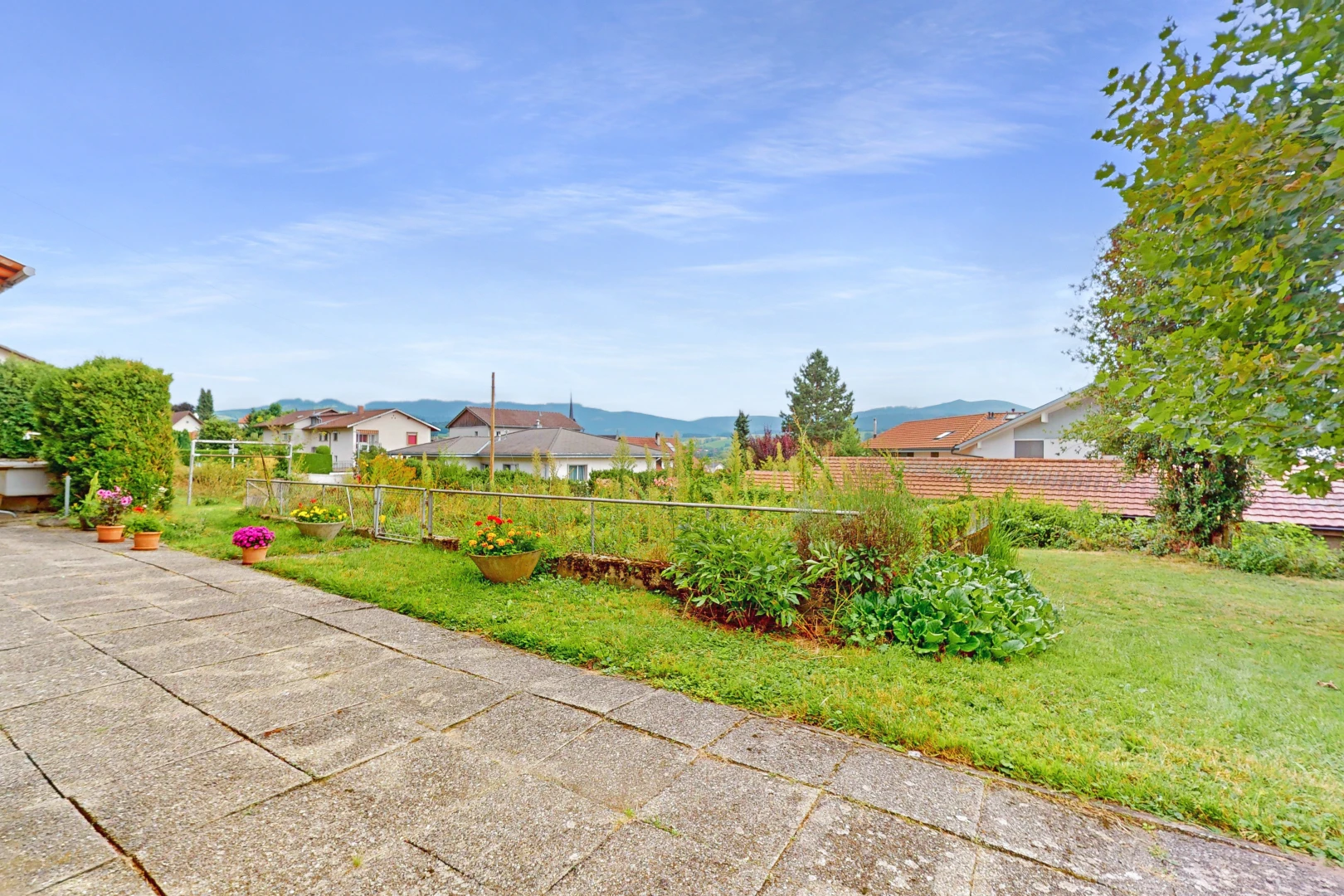 garten mit wohngebietblick, blick auf die berge, zaun, und rasen