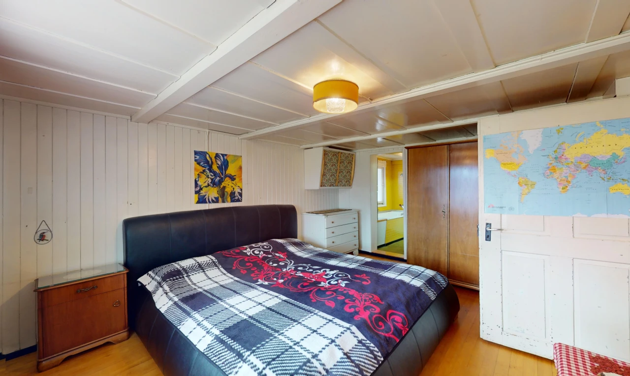 zimmer / schlafzimmer mit niedrige decke, kleiderschrank, und parkettboden