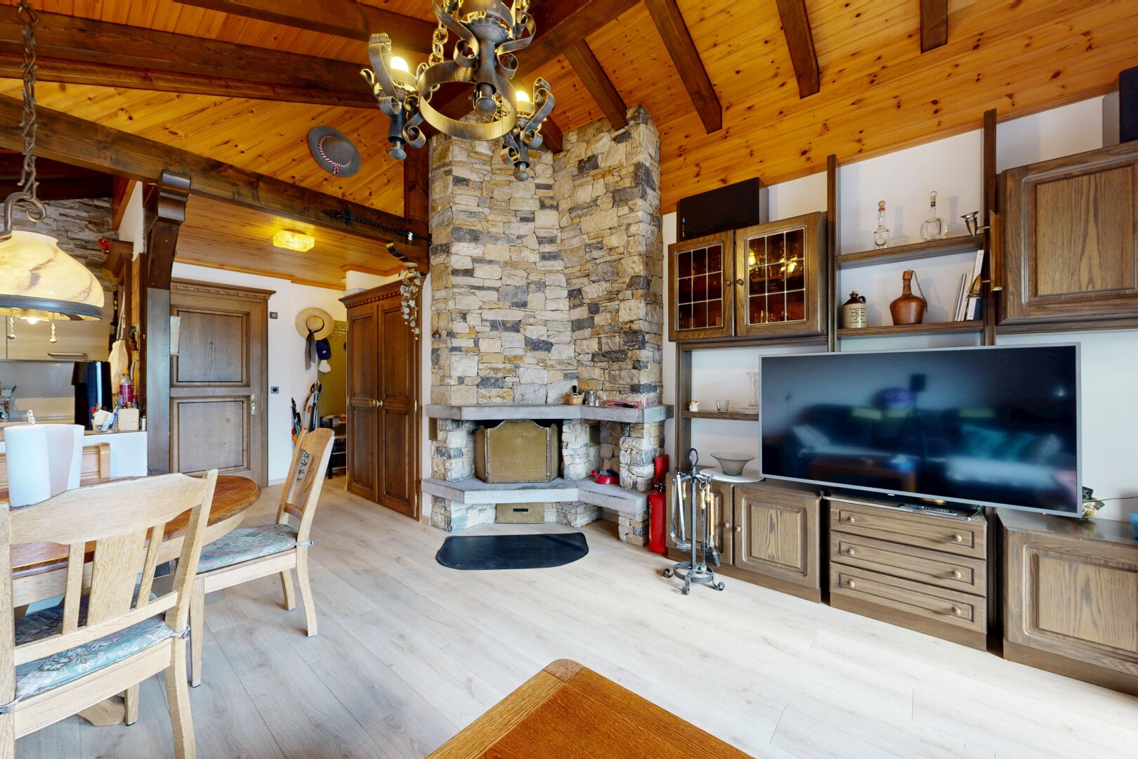 salon / salle à manger avec inside property, télévision, plafond à poutres, beamed ceiling, et sol en finition bois