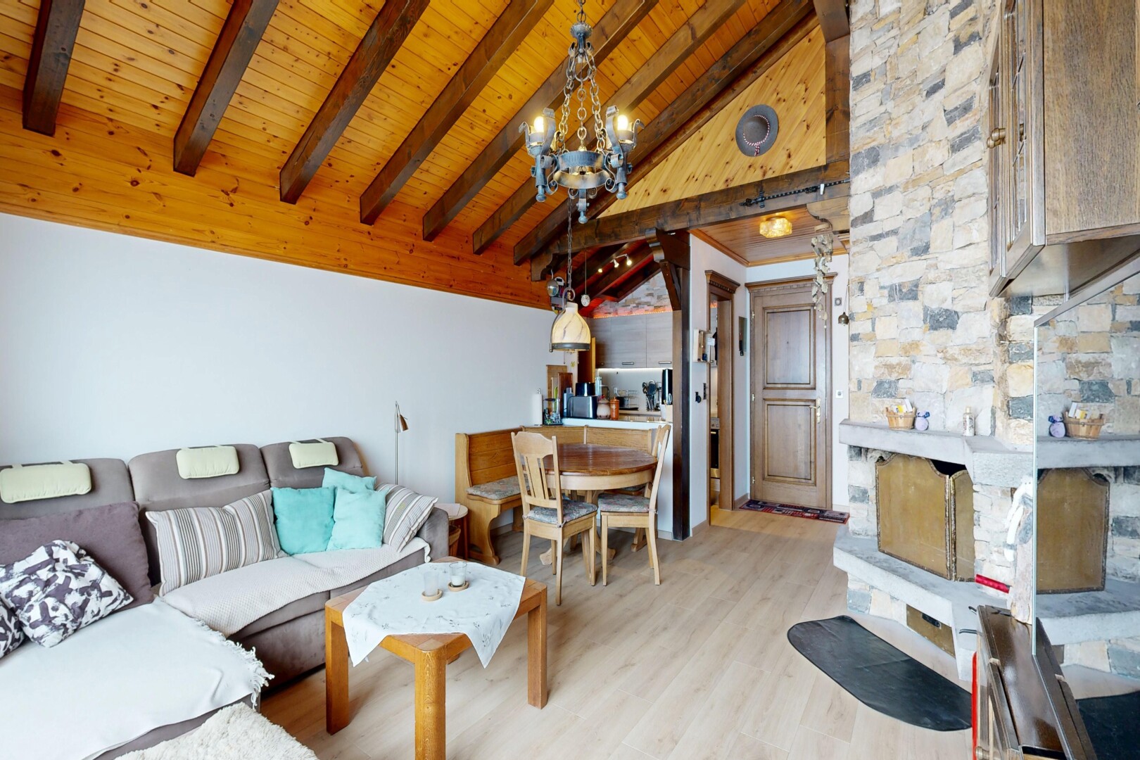 wohn- / esszimmer mit beamed ceiling, balkendecke, vaulted ceiling, dachschräge, und wood finish floor