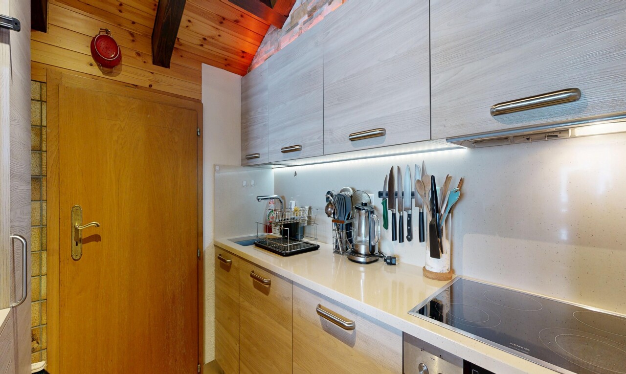 küche mit herd, arbeitsplatten, light countertops, inside property, und schränke mit flachen paneelen