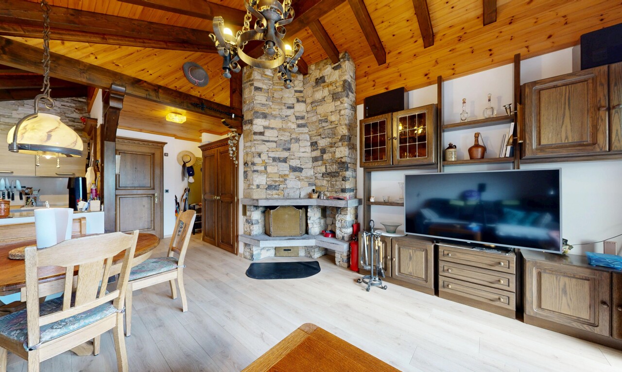 salon / salle à manger avec inside property, télévision, plafond à poutres, beamed ceiling, et sol en finition bois