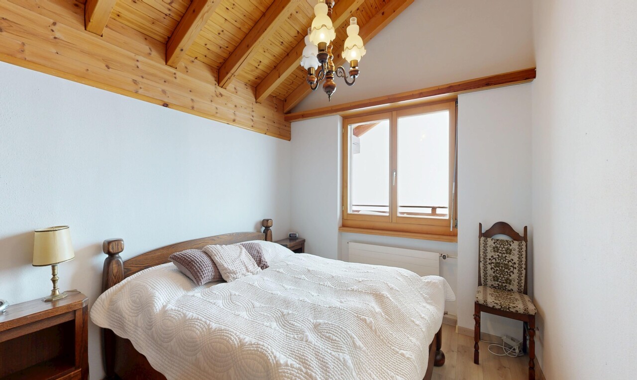 zimmer / schlafzimmer mit bemerkenswerter kronleuchter, inside property, gipskartonwand, drywall, und balkendecke