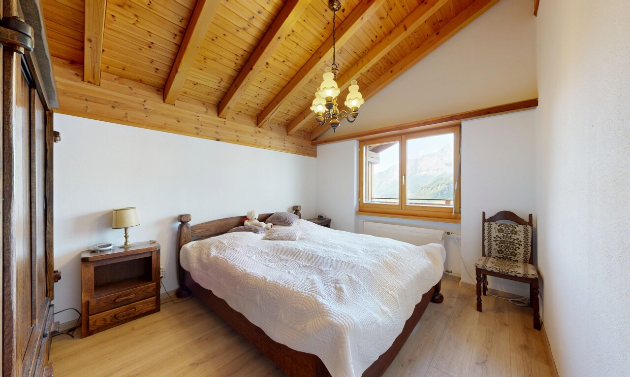 chambre avec plafond à poutres, beamed ceiling, inside property, sol en finition bois, et wood finish floor