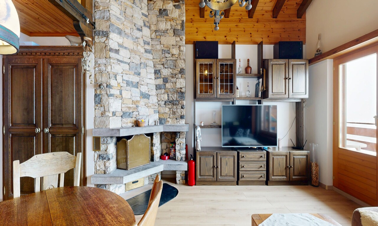 wohnzimmer mit fernseher, kamin, inside property, holzfußboden, und wood finish floor
