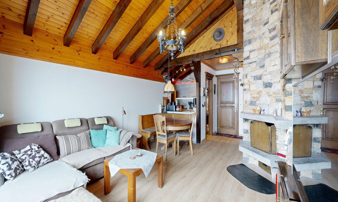 wohn- / esszimmer mit beamed ceiling, balkendecke, vaulted ceiling, dachschräge, und wood finish floor