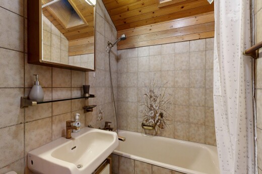 full bath with tiled shower / bath, tile walls, a skylight, a vaulted wooden ceiling, and vanity