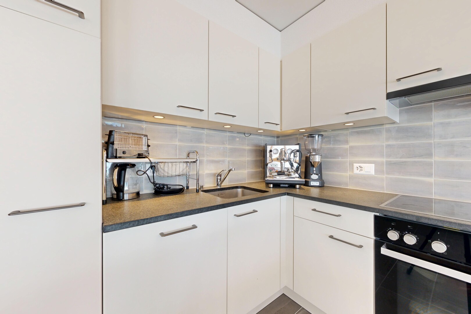 küche mit ofen, dark countertops, white cabinets, weiße schränke, und waschbecken