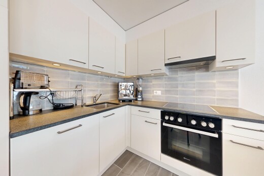 küche mit ofen, arbeitsplatten, dark countertops, light floor, und dunstabzugshaube