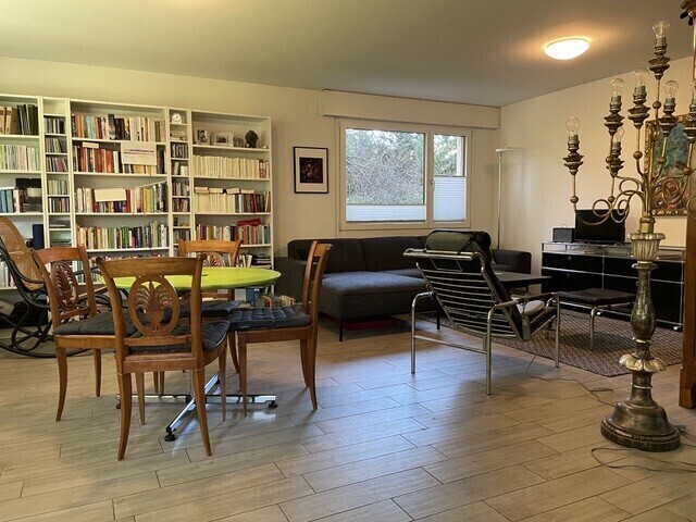 salon / salle à manger avec sol en finition bois, wood finish floor, cloison sèche, drywall, et light floor