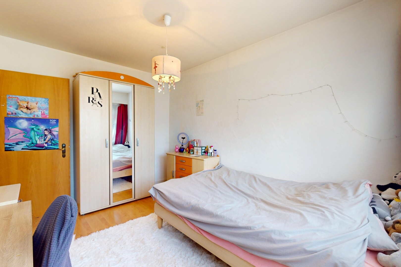 zimmer / schlafzimmer mit holzfußboden, gipskartonwand, und bemerkenswerter kronleuchter