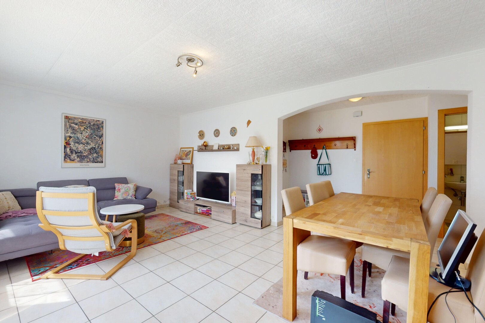 wohn- / esszimmer mit gipskartonwand, fliesenboden, fernseher, und gewölbte gehwege