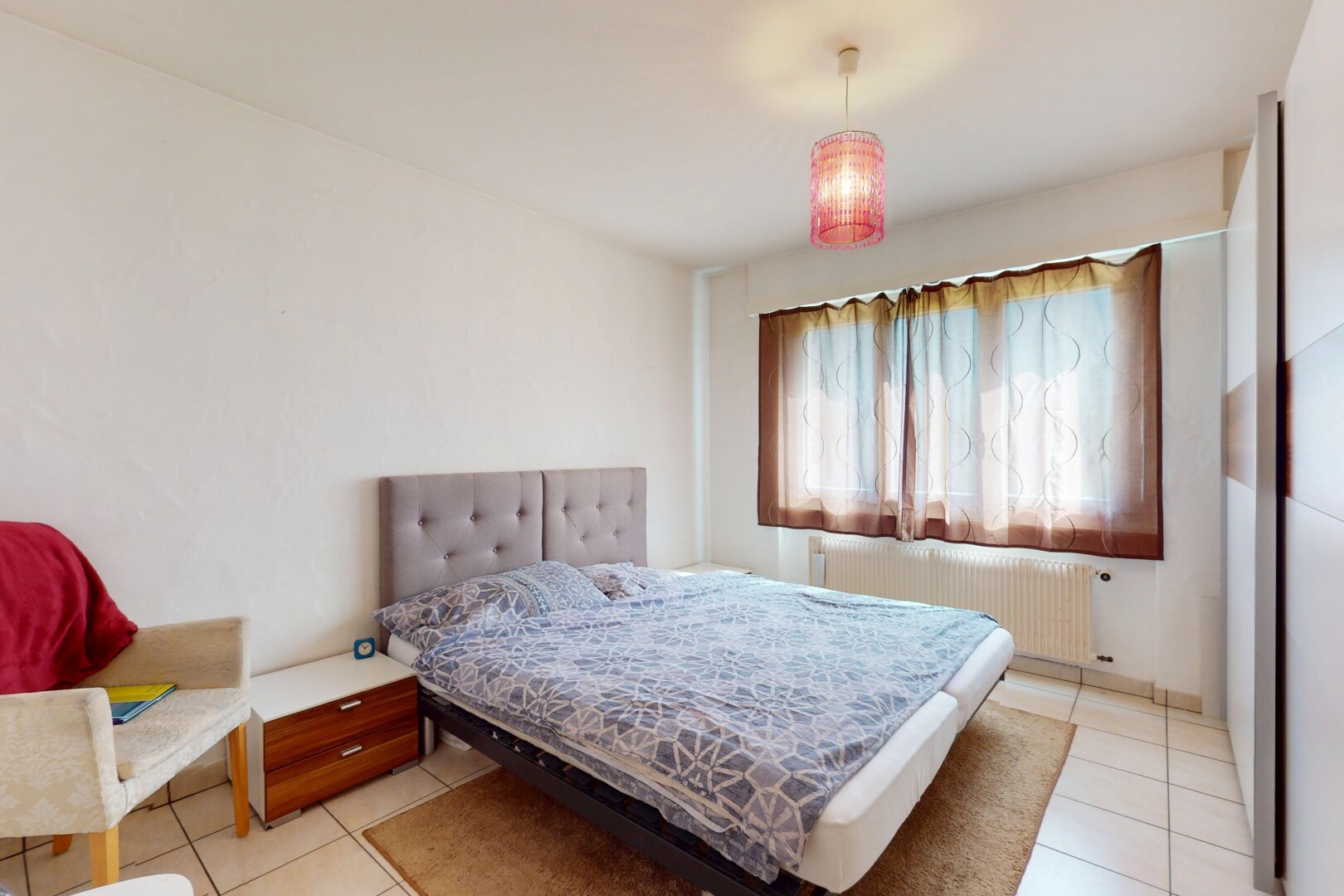 zimmer / schlafzimmer mit kühler, fliesenboden, gipskartonwand, und natürliches licht