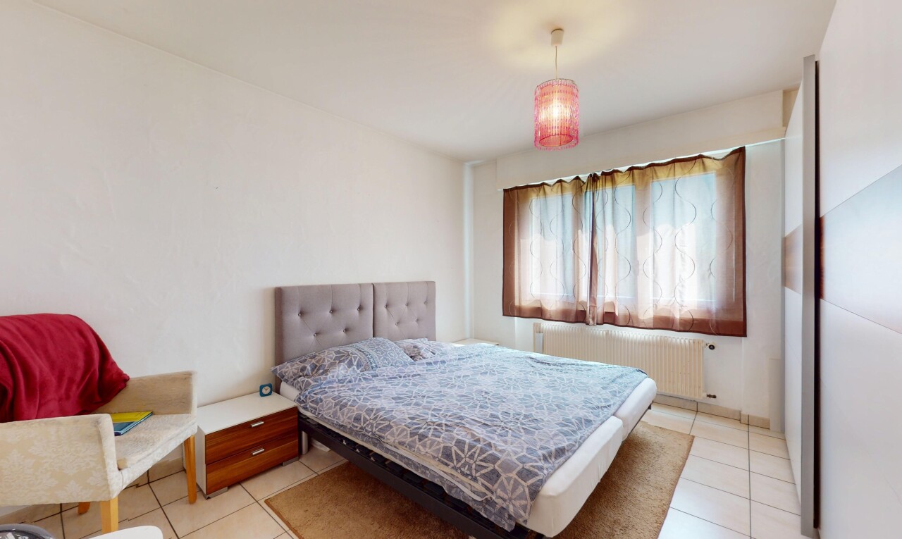 zimmer / schlafzimmer mit kühler, fliesenboden, gipskartonwand, und natürliches licht