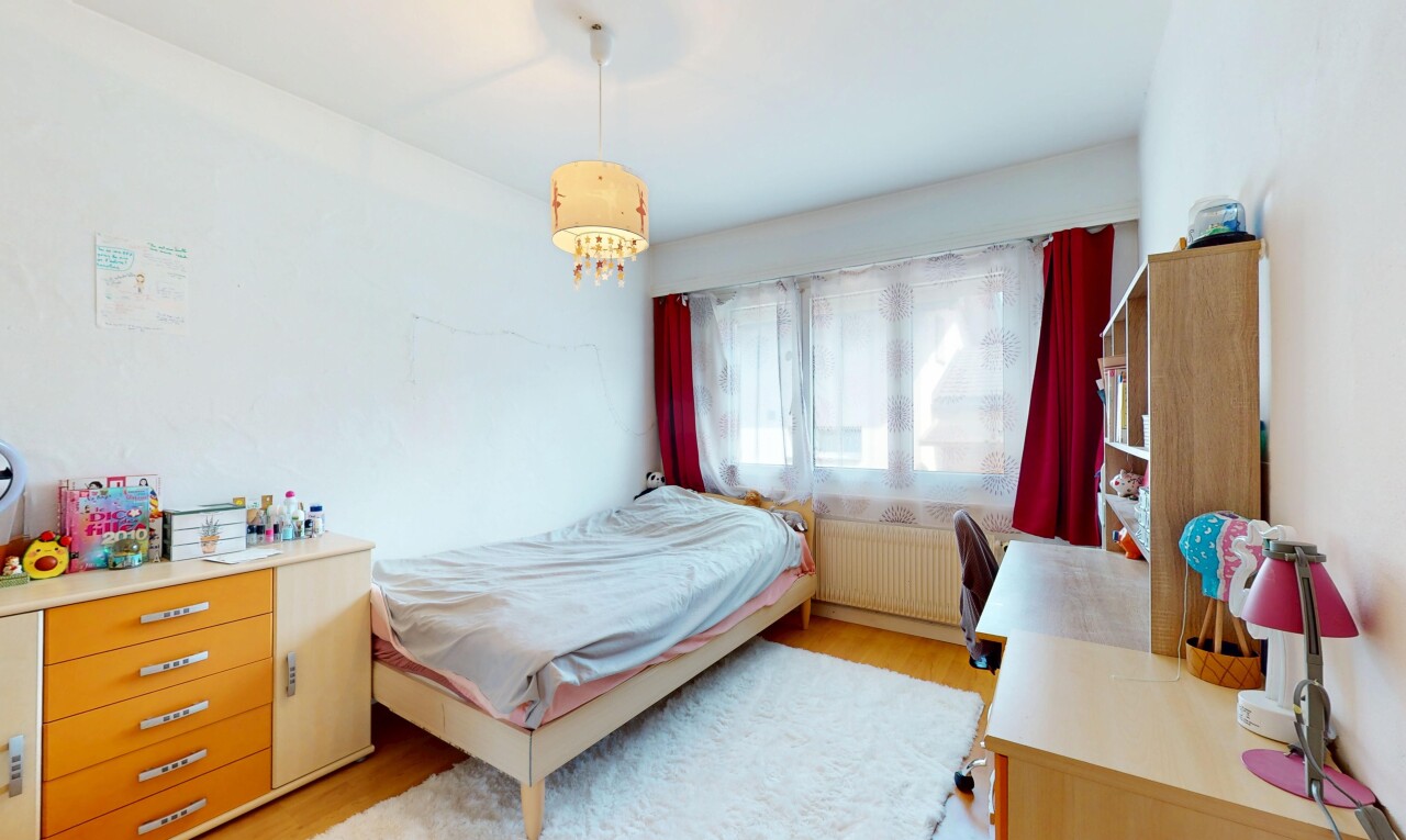 zimmer / schlafzimmer mit kühler, holzfußboden, gipskartonwand, und natürliches licht