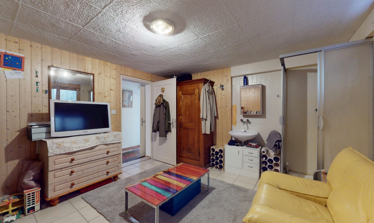 wohnzimmer mit holzwand, fernseher, und fliesenboden