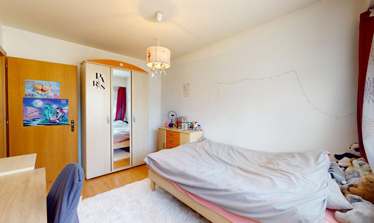 zimmer / schlafzimmer mit holzfußboden, gipskartonwand, und bemerkenswerter kronleuchter