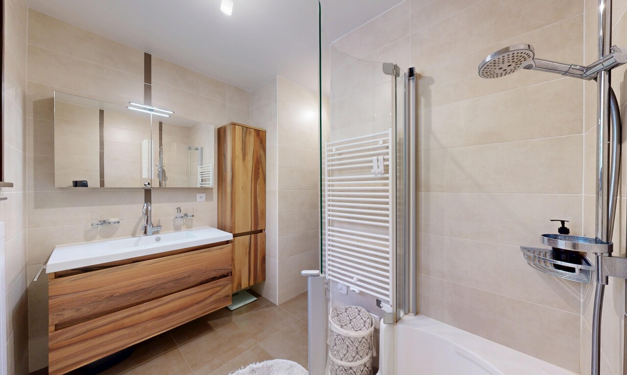 salle de bains avec chauffe-serviettes, tile wall, mur en carrelage, miroir, et salle de bain complète