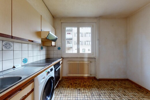 cuisine avec wood edge countertops, light floor, lave-linge et sèche-linge, radiateur, et hotte
