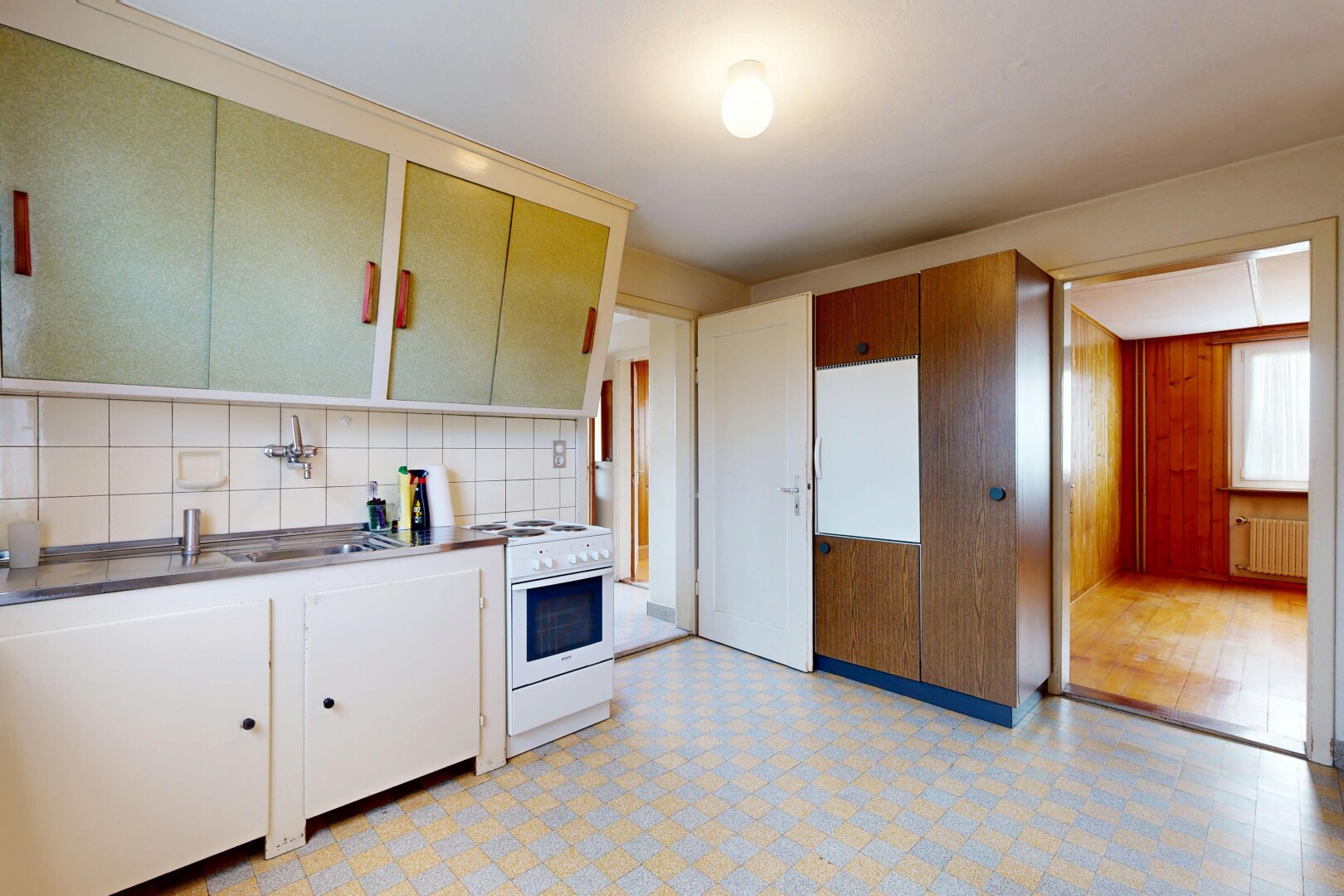 kitchen with light flooring, white range oven, radiator heating unit, backsplash, and white cabinets