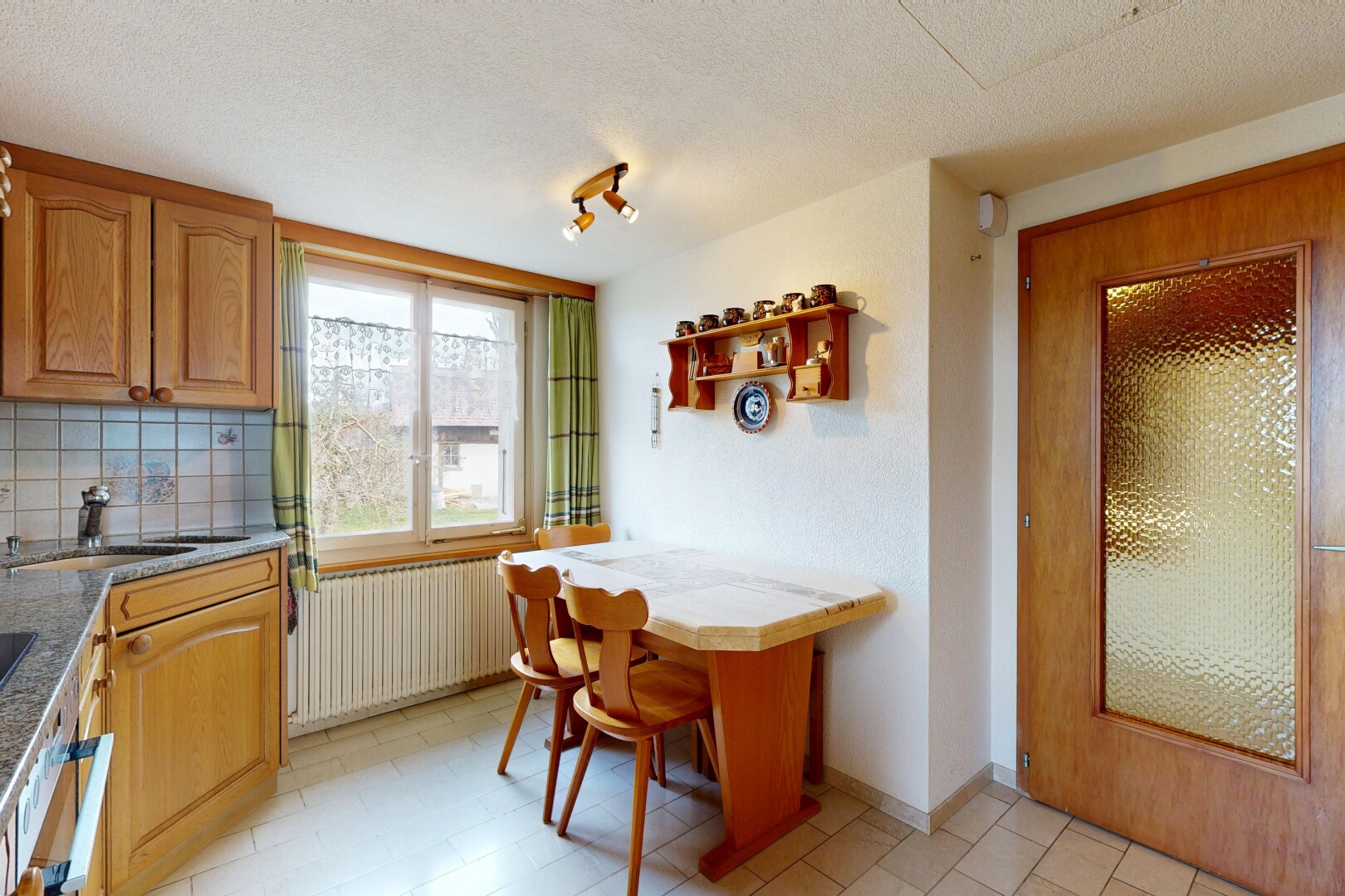kitchen featuring radiator, open shelves, a textured ceiling, decorative backsplash, and light stone counters