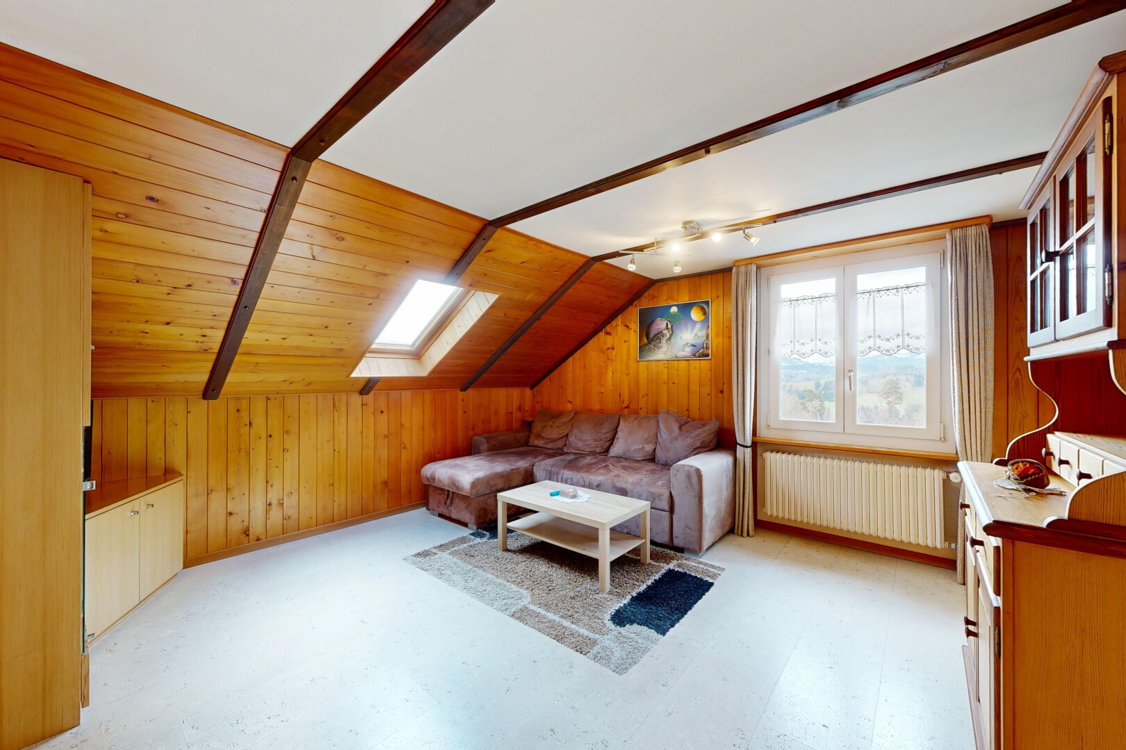 living room featuring radiator, vaulted ceiling, wooden walls, a skylight, and light floors