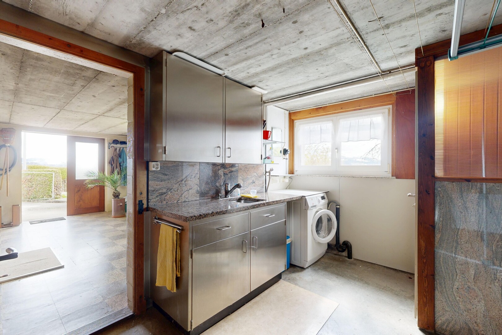 laundry area featuring concrete floors and washer / dryer