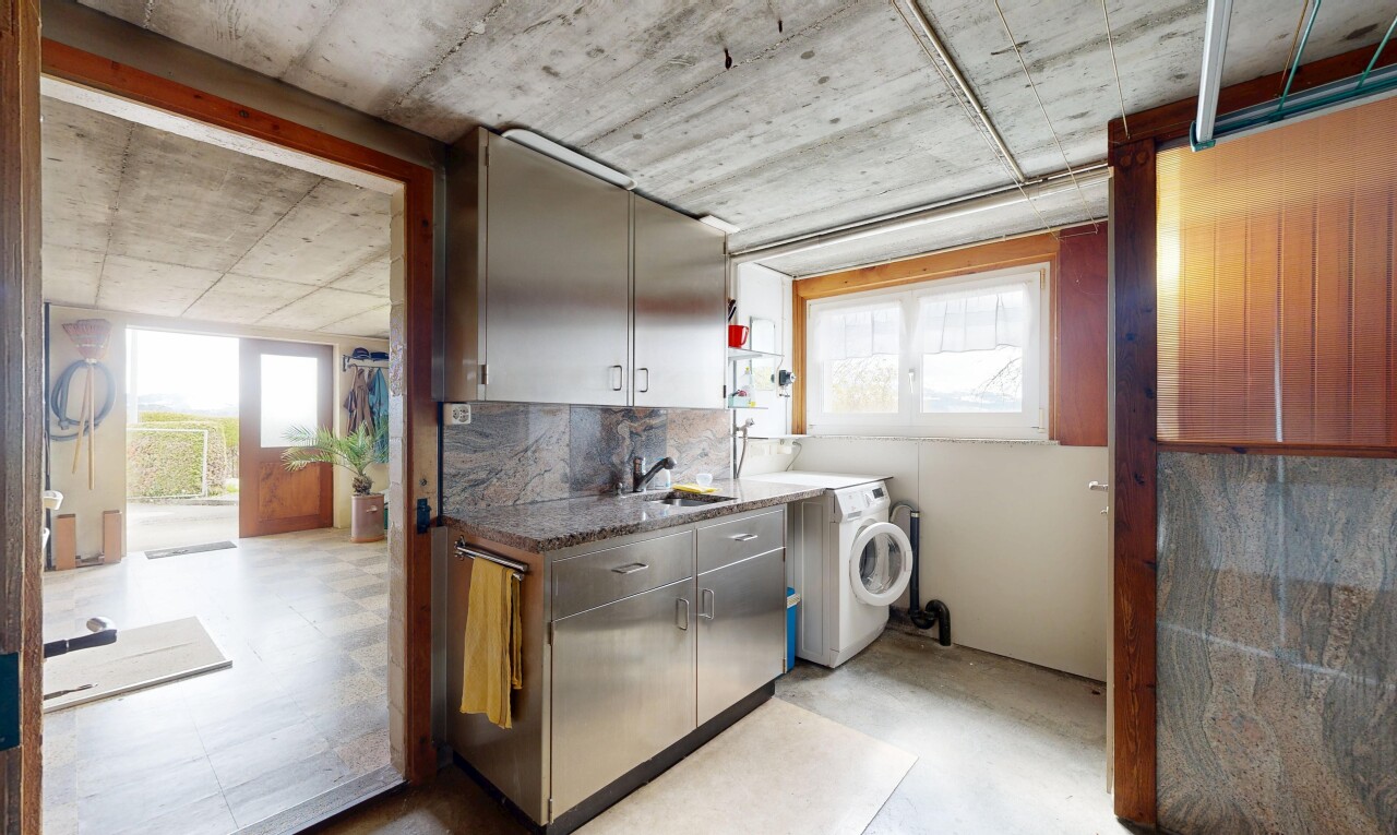 laundry area featuring concrete floors and washer / dryer