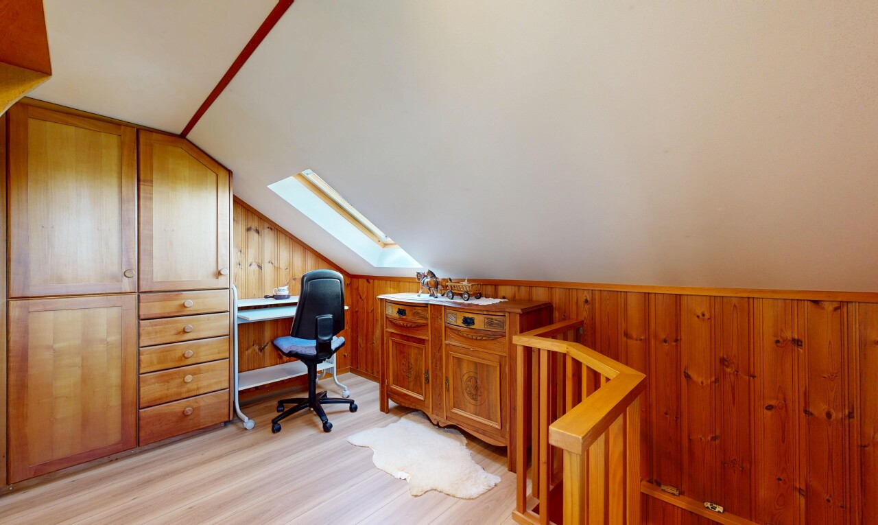 home office with wood walls, a skylight, vaulted ceiling, and light wood-style flooring