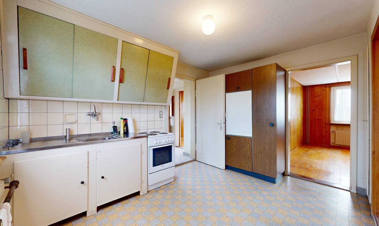 kitchen with light flooring, white range oven, radiator heating unit, backsplash, and white cabinets