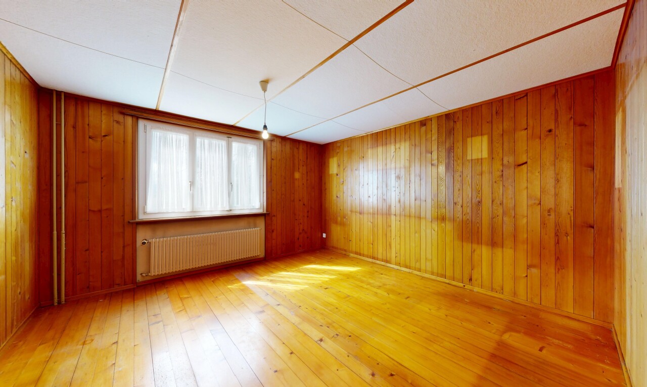 spare room featuring radiator heating unit, light wood finished floors, and wooden walls