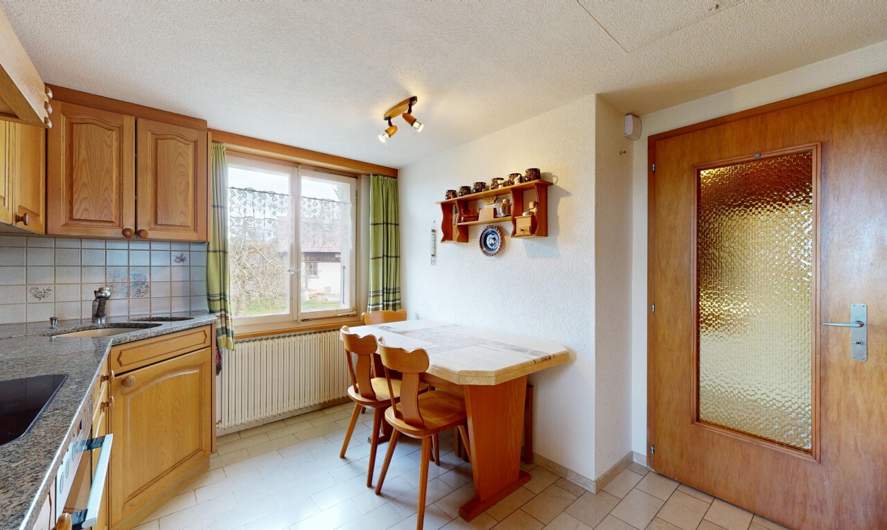 kitchen featuring radiator, open shelves, a textured ceiling, decorative backsplash, and light stone counters