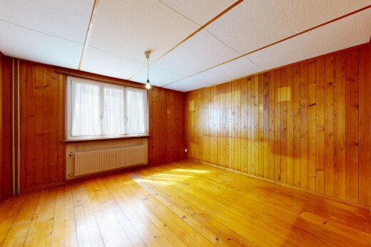 pièce vide avec radiateur, hardwood floor, sol en finition bois, wood finish floor, et mur en bois