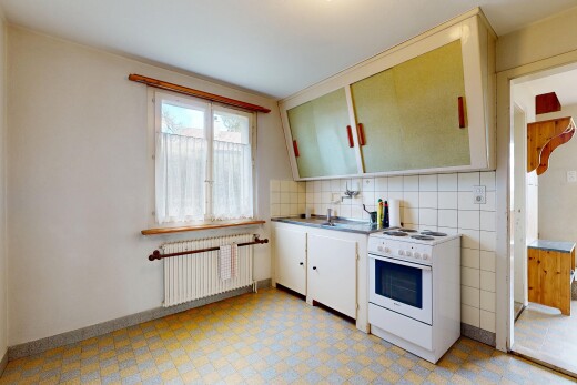 cuisine avec armoires blanches, white cabinets, cuisinière, radiateur, et light floor