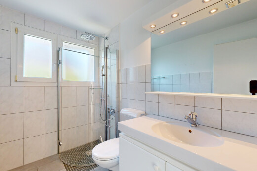 bathroom with a shower stall, vanity, tile walls, and light tile patterned floors