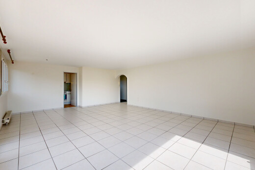spare room featuring arched walkways and light tile patterned floors