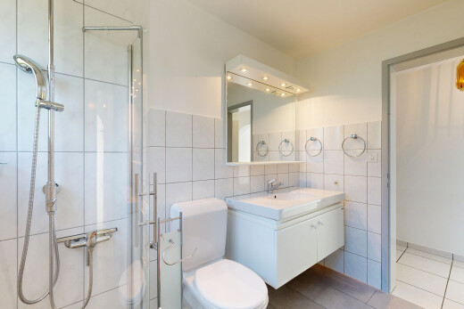 full bathroom with a shower stall, vanity, tile walls, and light tile patterned floors