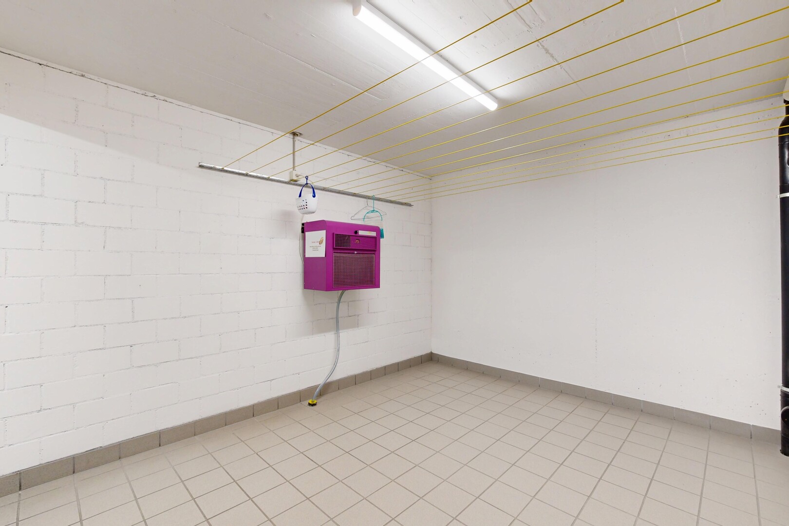 empty room featuring concrete block wall and light tile patterned flooring
