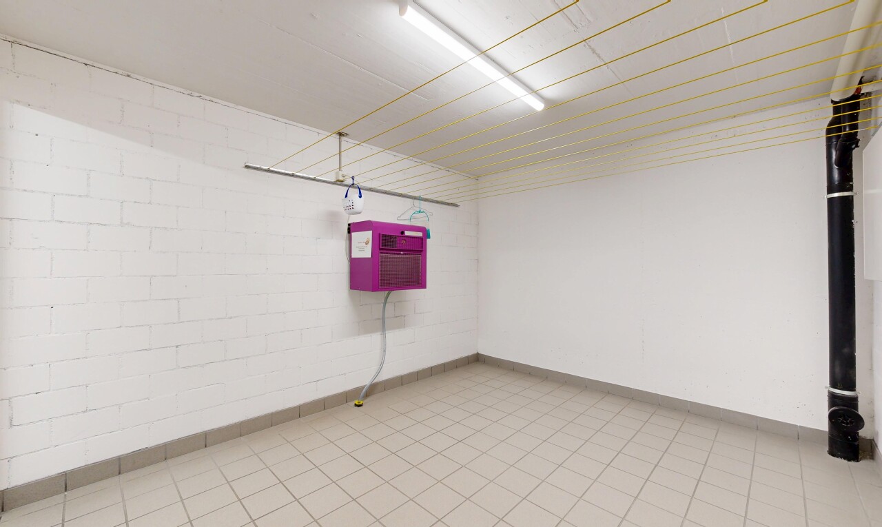 empty room featuring concrete block wall and light tile patterned flooring