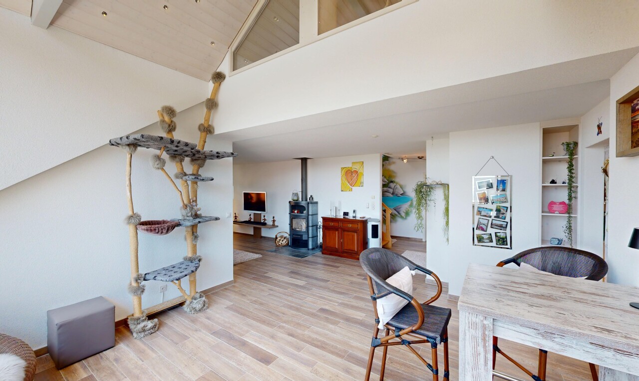 dining room featuring a wood stove, built in features, light wood-type flooring, and lofted ceiling