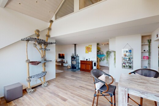 dining room featuring a wood stove, built in features, light wood-type flooring, and lofted ceiling