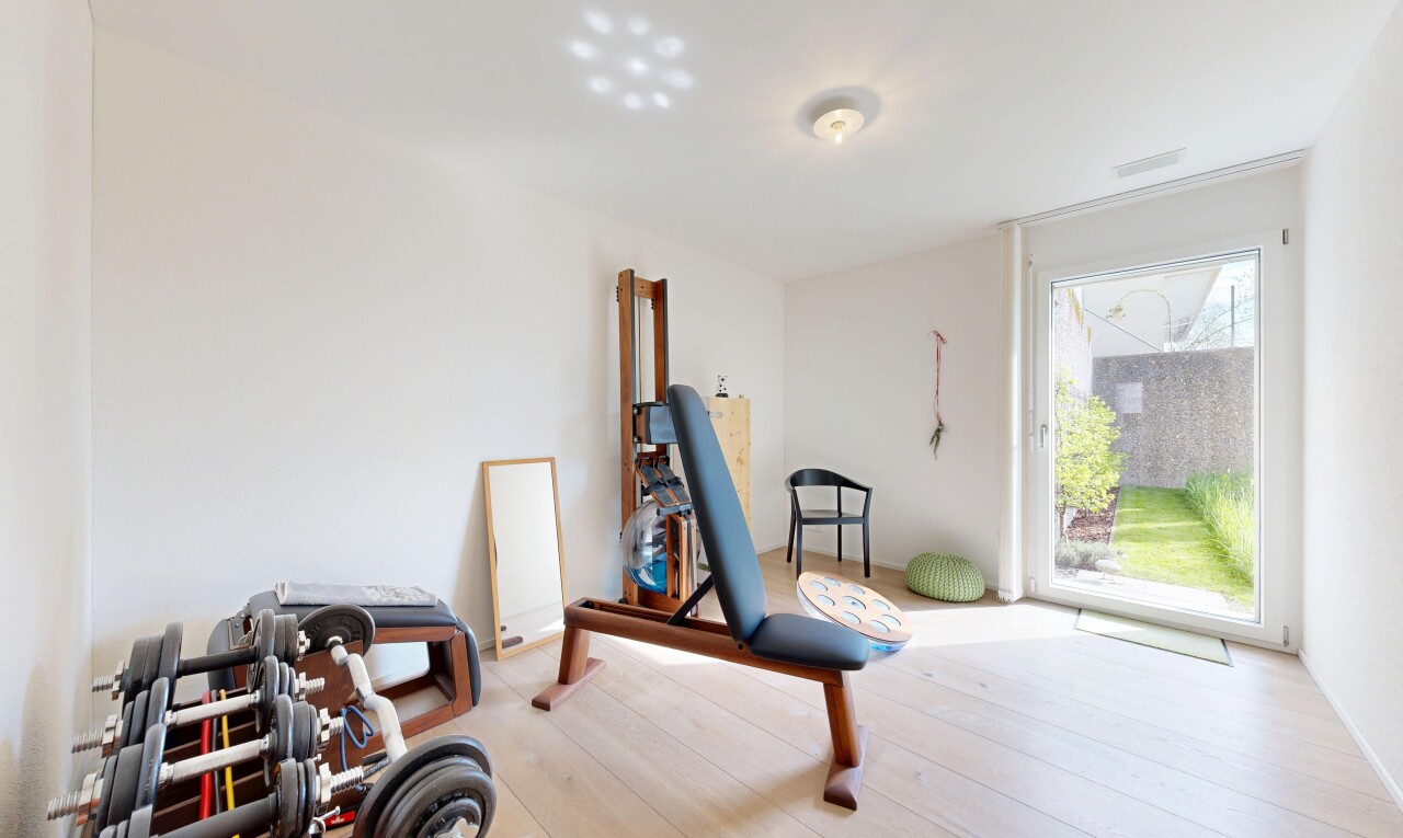 gym avec natural light, lumière naturelle, wood finish floor, sol en finition bois, et drywall